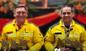 Dois instrutores da Sierra com uniforme amarelo segurando os troféus do Desafio Nacional do Trauma